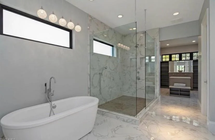 Marble bathroom with freestanding tub and walk-in shower by Blocco25